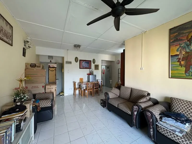 Living features: white painted walls, tiled flooring, 5-blade ceiling fan, 2-seater fabric sofa in brown, 3-seater fabric sofa in brown, coffee table, decorative wall art, open dining area, dining table with 6 chairs, storage cabinet, boxes stacked in corner.