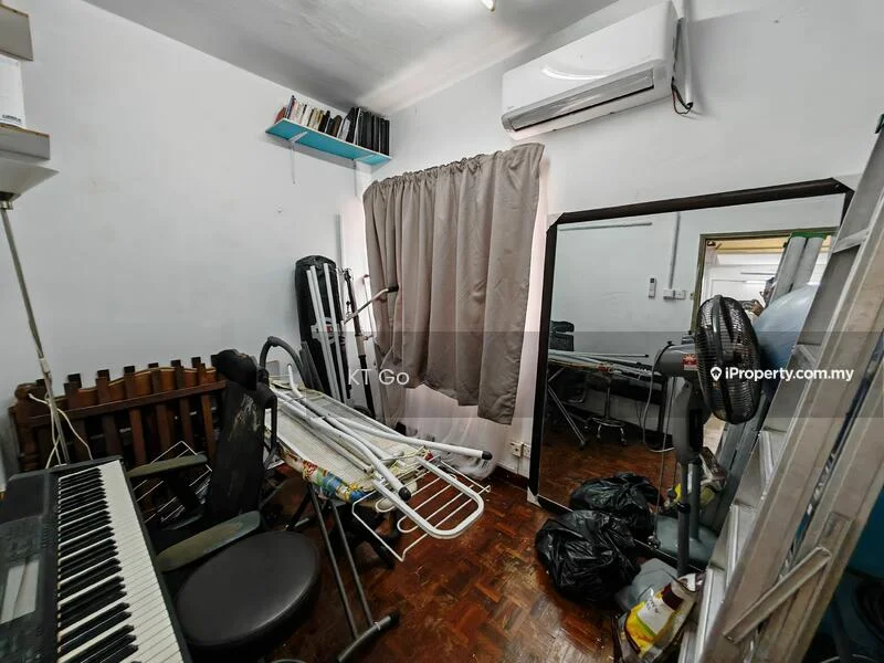 Room features: wooden flooring, white painted walls, air conditioning unit, curtains, full-length mirror, piano keyboard, folding drying rack, plastic bags, office chair, ladder, desk with computer equipment.