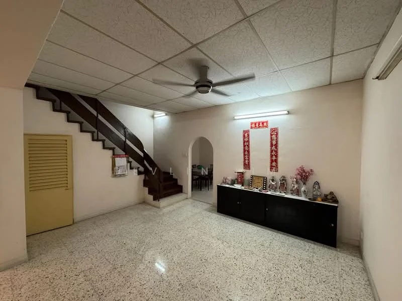Living features: white painted walls, textured ceiling, polished terrazzo flooring, 5-blade ceiling fan, arched doorway, wooden staircase, black console cabinet, decorative items on console, wall-mounted light, red decorative banners; style: traditional.