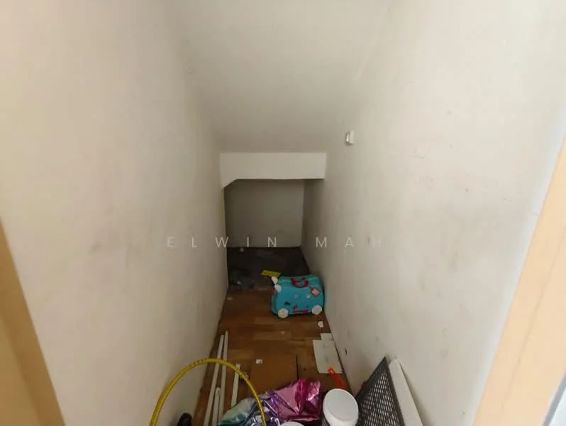 Room features: white painted walls, wood flooring, staircase leading down, cluttered with various items, dim lighting.