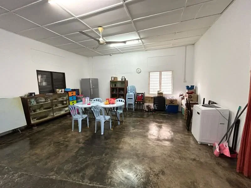 Room features: white painted walls, concrete flooring, ceiling fan, dining table with chairs, refrigerator, wooden shelving unit, various storage boxes, washing machine, window with blinds, clock on wall, pink cleaning tools; style: minimalist.