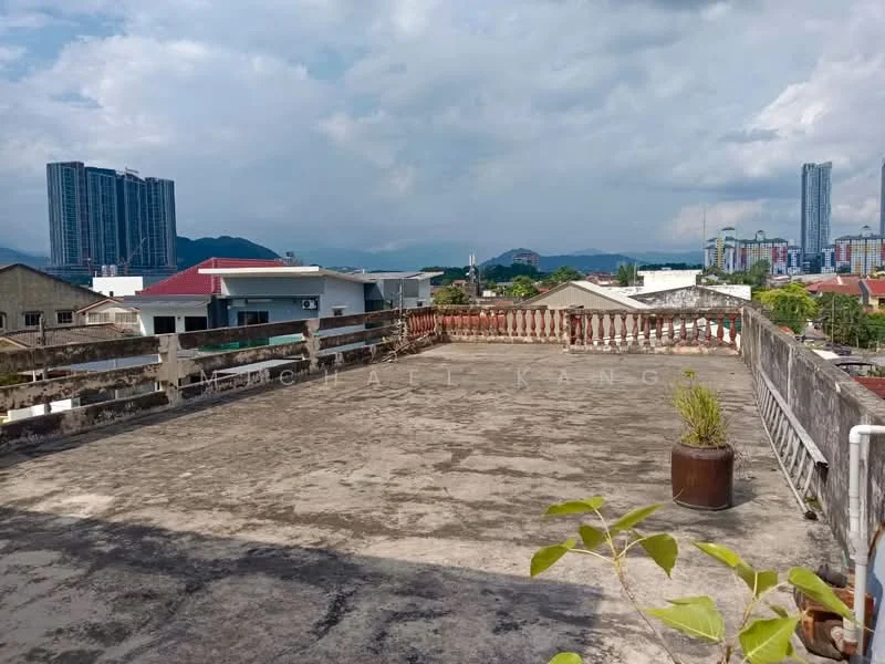 Exterior features: flat roof terrace, concrete flooring, surrounding low-rise buildings, city skyline in background, mountain view in distance, planter pot with greenery.