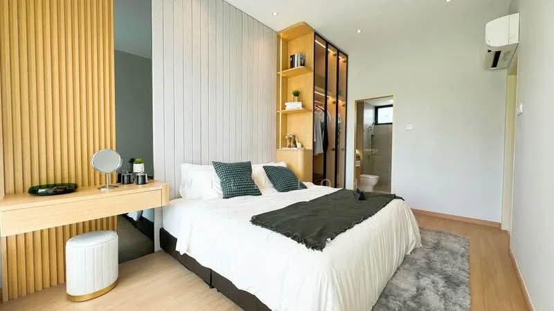 Bedroom features: king-size bed with white bedding, upholstered headboard, green accent pillows, wooden bedside table, round white stool, built-in wardrobe with glass doors, wood panel accent wall, recessed ceiling lights, wall-mounted air conditioning unit, light wood flooring, decorative mirror on the bedside table, area rug with soft texture; style: modern.
