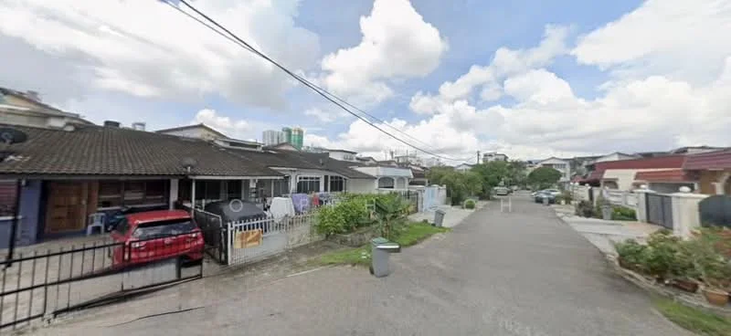 Exterior type: linked terrace house; features: single-storey, grey painted facade, gated entrance, manicured lawn, paved walkway, car parked in driveway, street view with residential context, surrounded by greenery, visible utility poles, cloudy sky; style: modern.