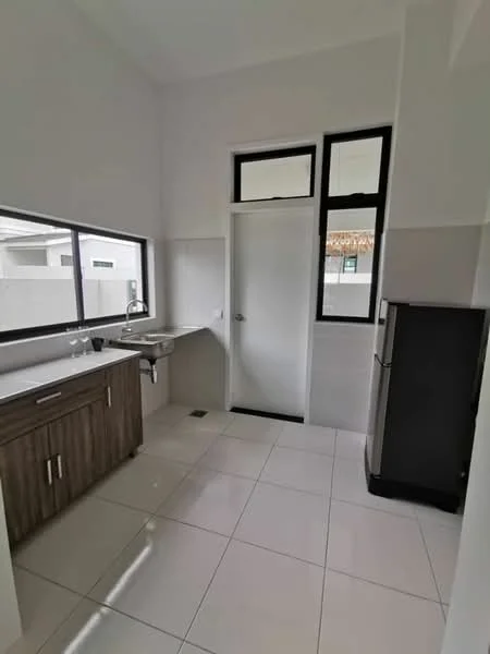 Kitchen features: white painted walls, grey tiled flooring, single-bowl stainless-steel sink, chrome pull-down faucet, wood cabinetry with dark finish, countertop space, refrigerator, large window for natural light, door leading to outside, light fixtures; style: modern.
