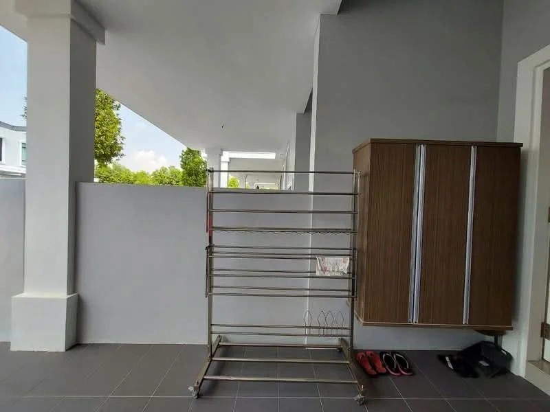 Room features: grey painted walls, floor tiles in dark colour, metal drying rack, wooden cabinet with sliding doors, slippers on the floor, outdoor space, natural light from above; style: modern.