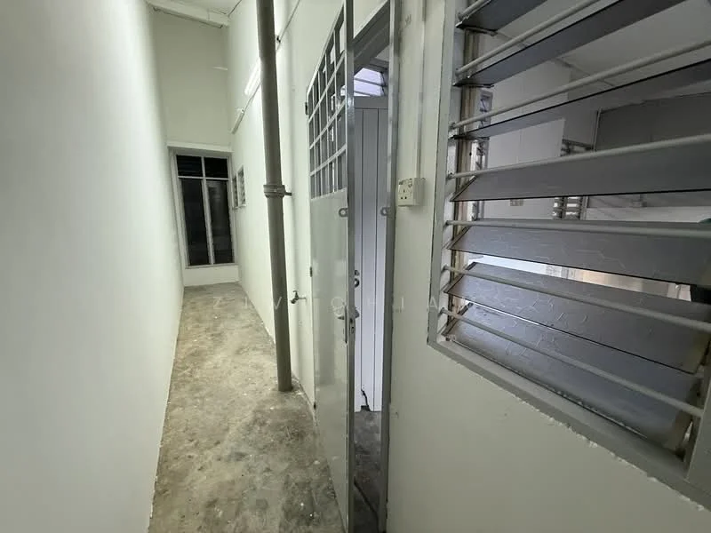 Room features: white painted walls, concrete flooring, metal security door, grilled windows, natural light from window, narrow hallway, exposed pipes; style: minimalist.