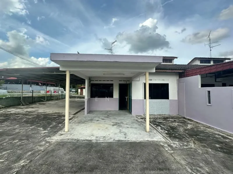 Exterior type: detached bungalow; features: single-storey building, purple painted facade, flat roof, concrete porch, large driveway, surrounded by open space, multiple windows, visible parking area; style: modern.