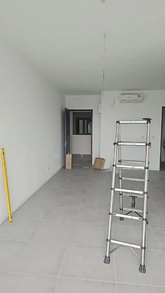 Room features: white painted walls, grey tiled flooring, 1 wall-mounted split AC, ceiling with exposed wiring, ladder, cardboard box, doorway leading to another room.