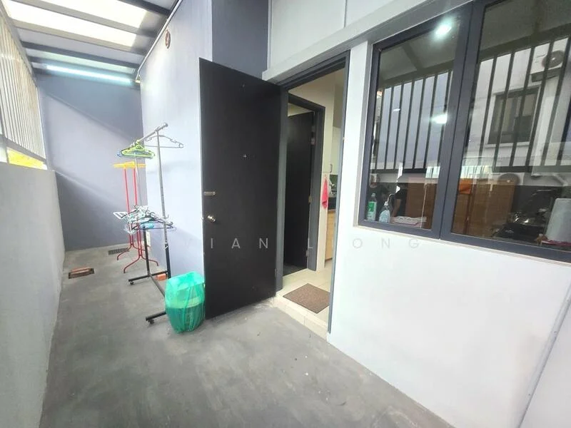 Room features: grey painted walls, concrete flooring, black door, large window with black frame, clothes rack, green trash bin, door mat, light fixture; style: modern.