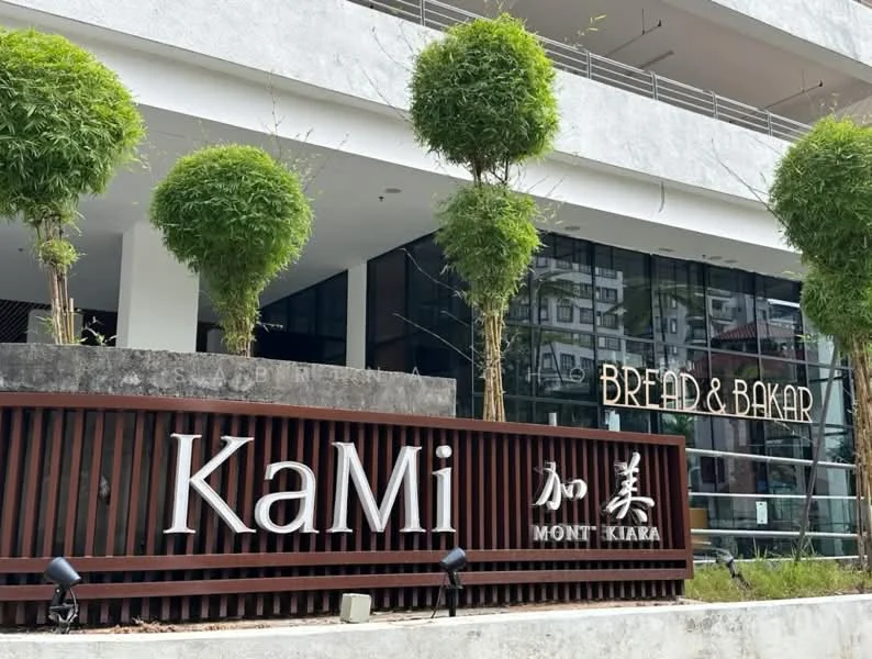 Exterior type: mixed-use development; features: modern facade, glass windows, wooden signage, landscaped greenery, bamboo plants, outdoor seating area, commercial space, prominent signage for Bread & Bakal, urban context with surrounding buildings; style: contemporary.