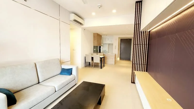Living features: 3-seater fabric sofa in light grey, blue decorative cushion, black coffee table, wall-mounted TV console, feature wall with textured panel, recessed lighting, light-colored tiled flooring, air conditioning unit, open layout to kitchen and dining area; style: modern.