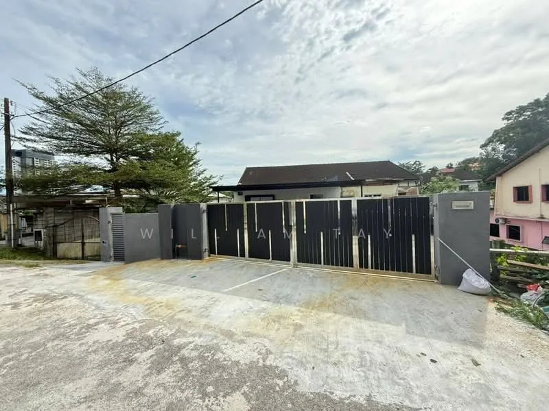 Exterior features: black metal gate, concrete driveway, surrounding greenery, single-storey building, asphalt road, trees in vicinity, residential area, fence, paved surface; style: modern.