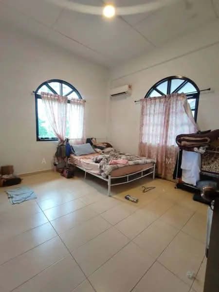 Bedroom features: queen-size bed, white bed frame, light-colored bedding, two windows with arched tops, sheer curtains, wall-mounted air conditioning unit, tile flooring, decorative wall paneling, clothing rack, small pile of boxes, area rug, light fixture in ceiling; view: garden.