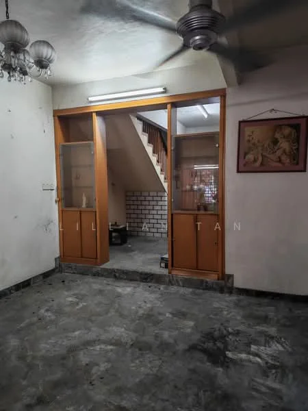 Room features: grey polished concrete flooring, white walls with some wear, wooden framed glass doors, ceiling fan, staircase visible in background, wall-mounted light fixture, framed artwork on wall, exposed ceiling; style: minimalist.
