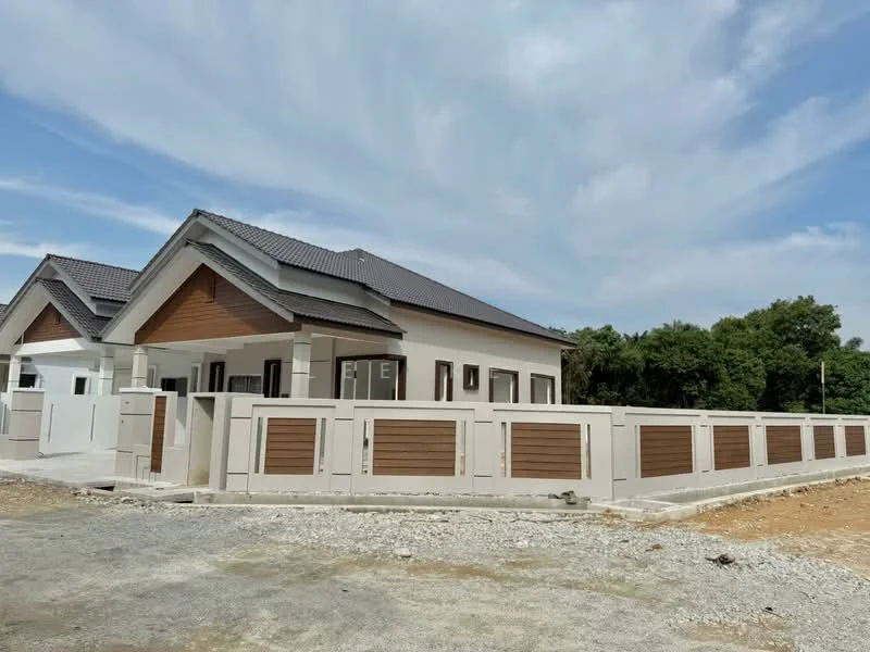 Exterior type: detached bungalow; features: white painted facade, wooden cladding accents, pitched tile roof, single-storey, manicured lawn, surrounded by greenery, perimeter fence, driveway with gravel, large windows, front porch; style: modern.