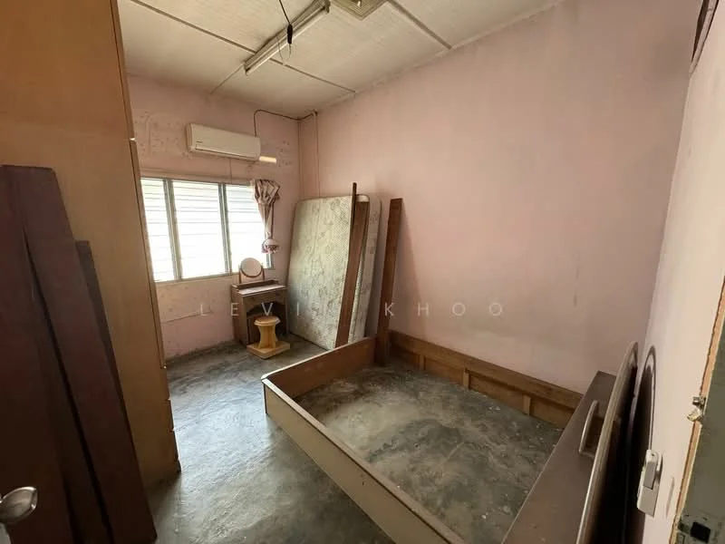 Bedroom features: pink painted walls, concrete flooring, window with sheer curtains, wall-mounted split AC, wooden bed frame, wooden bedside table, mattress leaning against the wall, light fixture on ceiling.