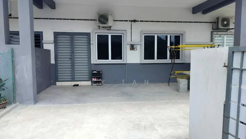 Exterior type: linked terrace house; features: grey painted facade, concrete flooring, 2 wall-mounted split AC units, 2 windows with white frames, metal security grille door, open parking space, yellow metal rack, green fence, manicured plants in pots; style: modern.