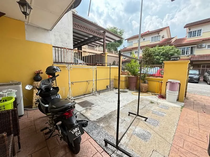 Exterior type: linked terrace house; features: paved driveway, yellow painted walls, outdoor clothes drying rack, motorcycle parked, garden area with potted plants, covered porch, surrounding residential buildings, stone-paved walkway; style: modern.