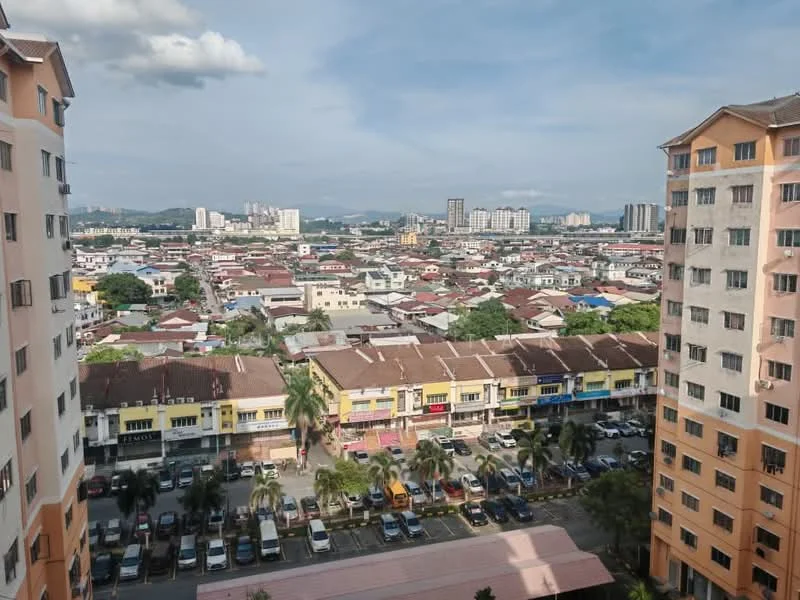 Exterior type: high-rise condominium; features: city skyline view, surrounded by residential buildings, parking lot visible, multi-storey buildings, urban landscape, greenery in the foreground; style: modern.