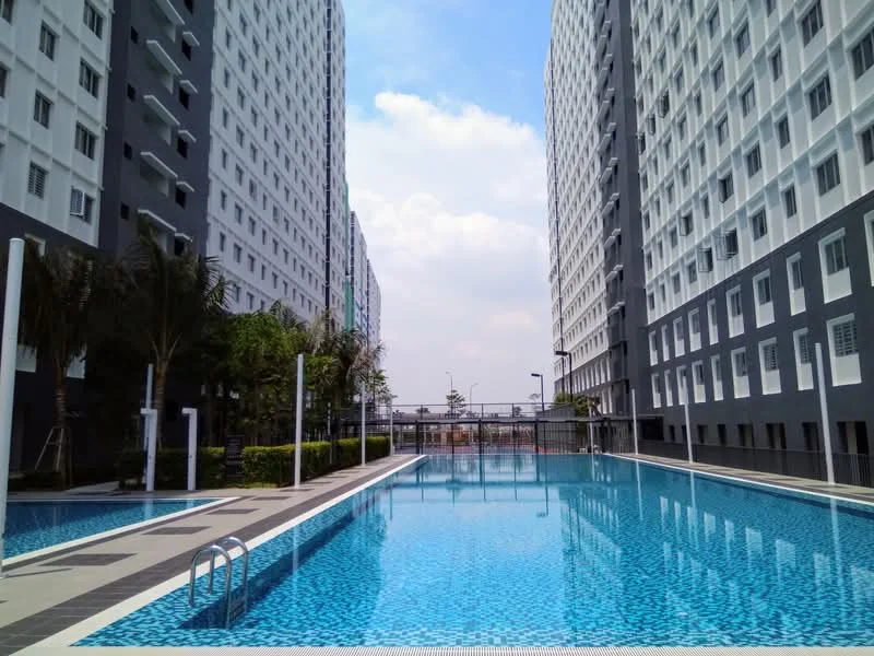 Exterior type: high-rise condominium; features: infinity pool, pool deck with loungers, surrounded by palm trees, manicured landscaping, two high-rise buildings flanking the pool, glass curtain wall facade, outdoor lighting, paved walkway around the pool; style: modern.