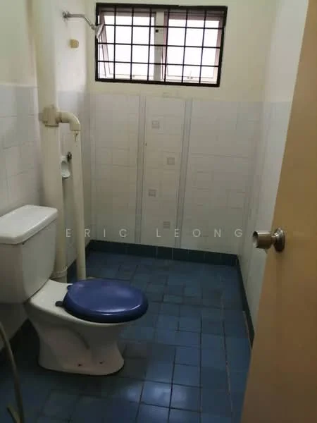 Bathroom features: one-piece toilet, blue ceramic tile flooring, white tiled walls, shower head, window with metal grille, sink with faucet, wall-mounted plumbing, door with knob.
