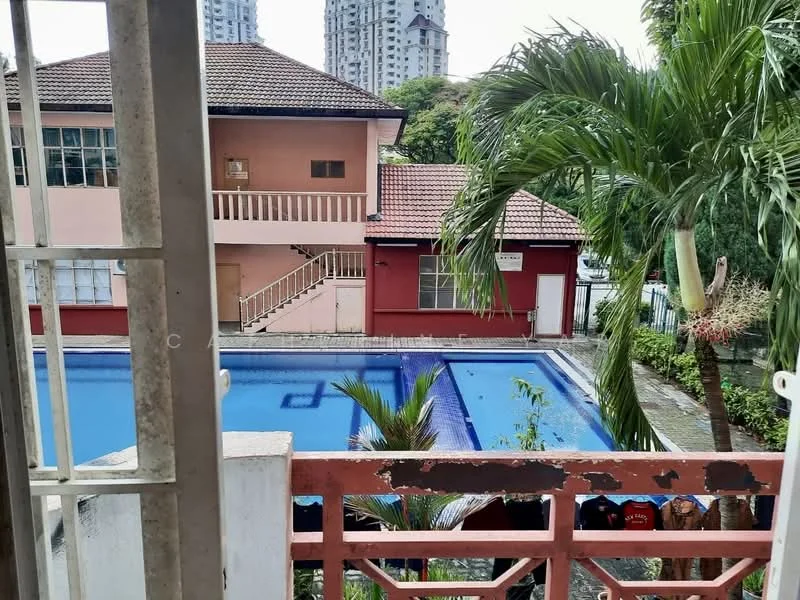 Exterior type: low-rise apartment block; features: swimming pool, manicured landscaping, palm trees, red painted facade, flat roof, two-storey building, balcony view of pool, surrounded by greenery; style: modern.