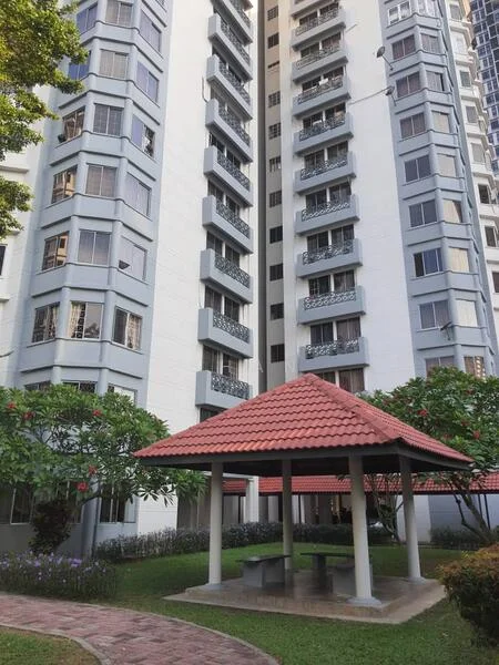 Exterior type: high-rise condominium; features: white painted facade, balconies with metal railings, red tiled gazebo, manicured lawn, landscaped garden with flowering plants, paved walkway, multiple storeys, surrounded by greenery; style: modern.