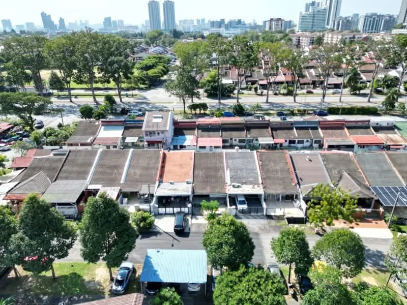 Exterior type: linked terrace house; features: single-storey houses, red tiled roofs, front porches, manicured lawns, paved driveways, surrounded by mature trees, urban context with city skyline in background, open-air parking, neighborhood with green spaces; style: traditional.