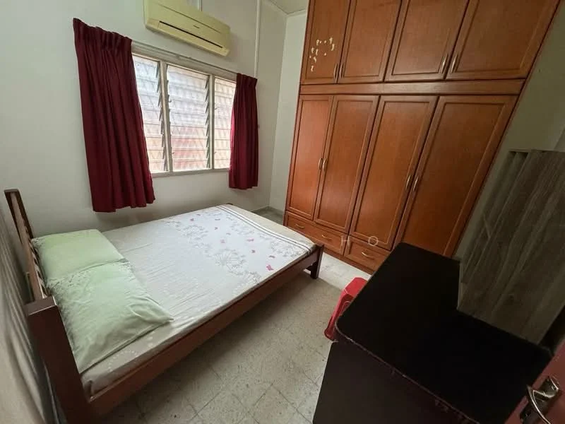Bedroom features: single bed, green decorative pillows, wooden wardrobe with sliding doors, wooden bedside table, red curtains, window with grid pattern, air conditioning unit, tile flooring.