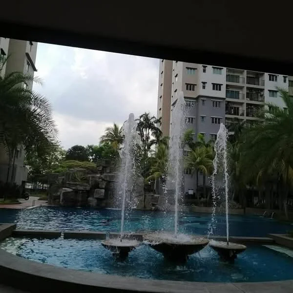Exterior type: high-rise condominium; features: swimming pool with fountains, rock feature in pool area, palm trees surrounding pool, manicured landscaping, residential buildings in background, outdoor seating area; style: modern.