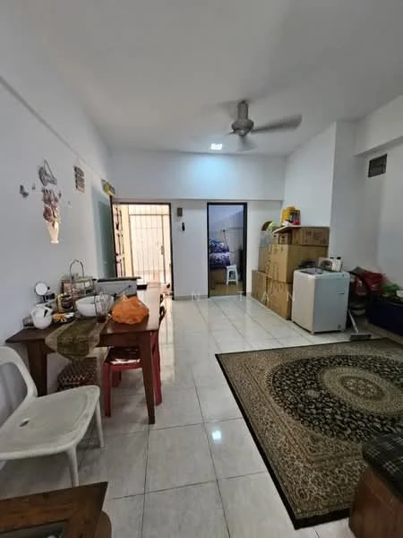 Living features: white painted walls, glossy ceramic tile flooring, 5-blade ceiling fan, area rug with geometric pattern, dining table with chairs, refrigerator, stacked cardboard boxes, plastic chair, decorative wall art, doorway leading to another room.