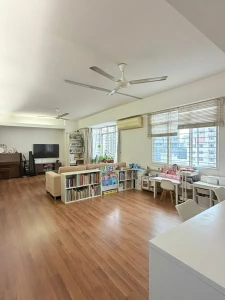 Living features: wooden flooring, 3-blade ceiling fan, floor-to-ceiling windows, white walls, built-in bookshelves, TV console, sofa, children's play area with table and chairs, air conditioning unit; style: modern; view: city.