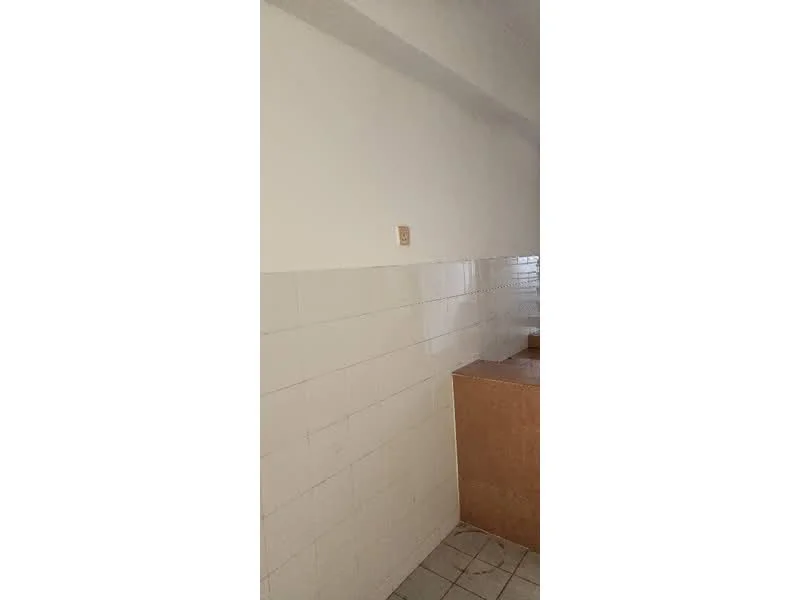 Room features: white painted walls, white tiled backsplash, light-colored cabinetry, tile flooring.