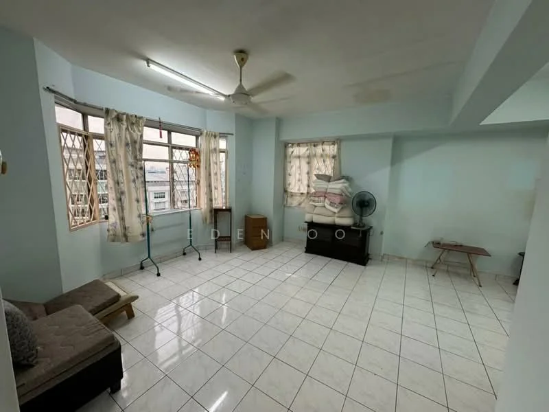Room features: light blue painted walls, white tiled flooring, ceiling fan, large windows with metal grilles, curtains on windows, corner table, stacked cushions on a chest, seating area with sofa, floor fan; view: city.