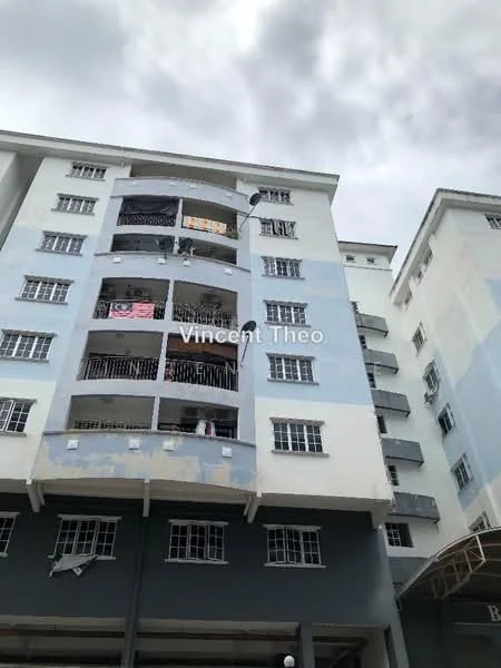 Exterior type: low-rise apartment block; features: white painted facade, blue accent walls, balconies with railings, multiple storeys, visible laundry on balconies, windows with grilles, overhang at entrance, parking area visible; style: modern.