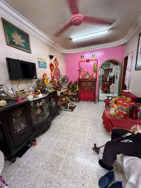 Living features: pink painted walls, white ceiling, 5-blade ceiling fan in pink, wall-mounted TV, glass display cabinet, wooden sideboard, decorative wall art, area rug, seating area with red tablecloth, various decorative items, flooring with speckled tiles; style: traditional.