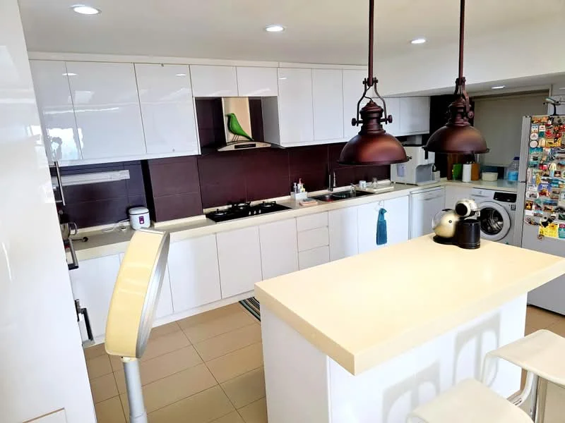 Kitchen features: white cabinetry, black countertop, stainless-steel gas hob, built-in oven, double-bowl stainless-steel sink, chrome pull-down faucet, pendant lighting with bronze finish, tile flooring, refrigerator with magnets, washing machine, open shelving, kitchen island with seating, decorative green bird figurine; style: modern.