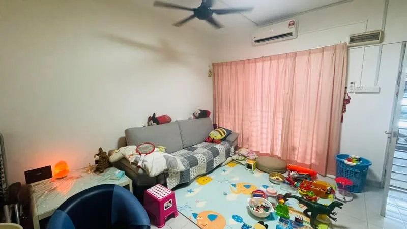 Living features: 3-seater fabric sofa in grey, ceiling fan, light pink sheer curtains, tile flooring, decorative salt lamp, colorful area rug with fish pattern, children's toys scattered on the floor, wall-mounted air conditioning unit, small round pet bed.