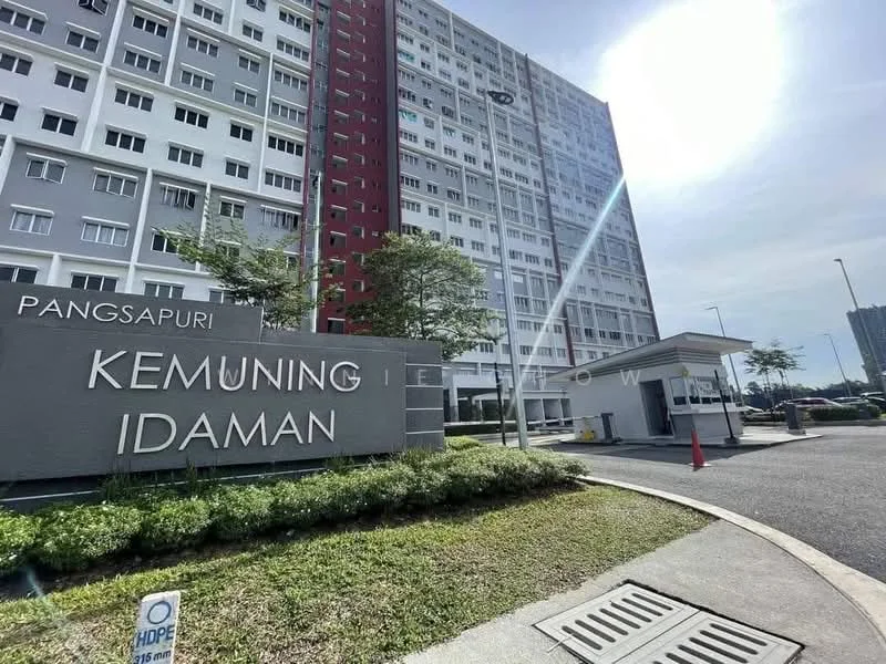 Exterior type: high-rise condominium; features: grey painted facade, red accent wall, main entrance gate, landscaped garden, manicured lawn, security guard house, paved driveway, surrounded by greenery; style: modern.