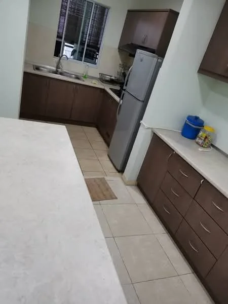 Kitchen features: single-bowl stainless-steel sink, chrome pull-down faucet, laminate countertop, brown wooden cabinetry, built-in refrigerator, ceramic tile flooring, window with blinds, kitchen island with overhang, wall-mounted cabinets, countertop with storage drawers; style: modern.