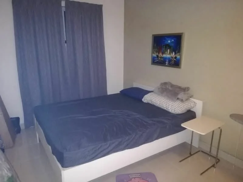 Bedroom features: queen-size bed with dark bedding, plaid blue pillow, white bed frame, side table with metal legs, framed artwork on wall, grey curtains, tile flooring, light-colored walls; style: modern.