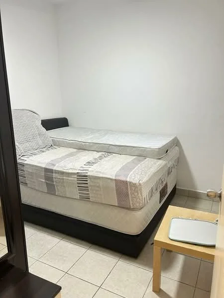 Bedroom features: two single beds, mattress on bed frame, white walls, tile flooring, small wooden table, lamp on floor, window with no visible treatment, minimal decor; style: minimalist.