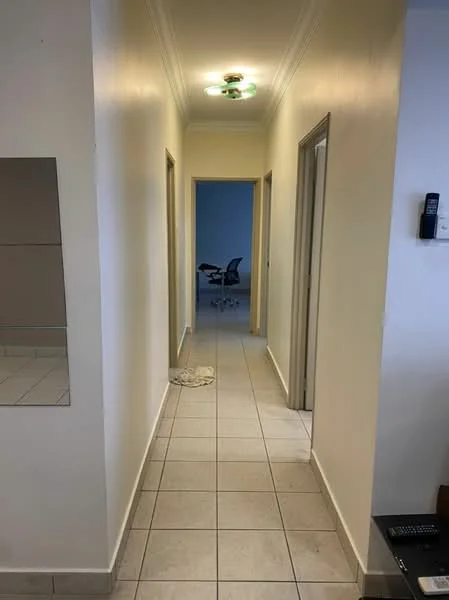 Hallway features: white painted walls, tile flooring, recessed ceiling lights, mirror on wall, doorways leading to other rooms, neutral color scheme; style: modern.