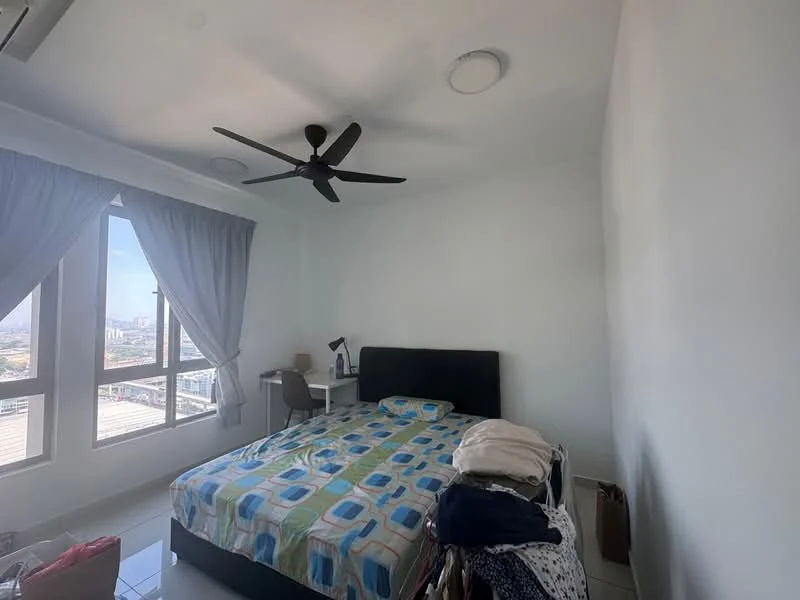 Bedroom features: queen-size bed with patterned bedding, 2 bedside lamps, study desk with chair, floor-to-ceiling windows, grey curtains, ceiling fan with light, white painted walls, tile flooring, stack of clothes on chair, laundry basket; style: modern; view: city.