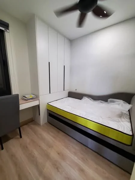 Bedroom features: single bed with mattress, built-in wardrobe with sliding doors, study desk, grey upholstered chair, wooden flooring, ceiling fan, white painted walls, window with black frame; style: modern.