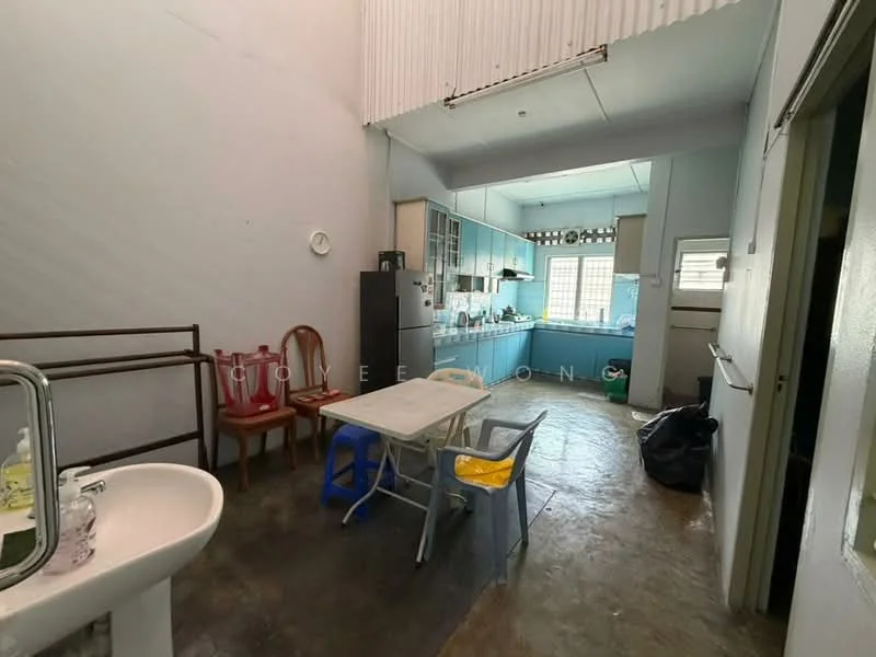 Kitchen features: blue cabinetry, stainless-steel sink, single-bowl sink, chrome faucet, countertop with space for appliances, refrigerator, open layout, concrete flooring, large window for natural light, dining table with chairs, plastic chairs in various colors, wall-mounted shelves, exposed ceiling, utility area with washing machine space; style: minimalist.