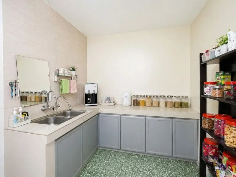 Laundry features: double-bowl stainless-steel sink, chrome pull-down faucet, grey cabinetry, light-colored countertop, green speckled flooring, wall-mounted mirror, shelf with jars and containers, appliances including water dispenser and kettle; style: modern.