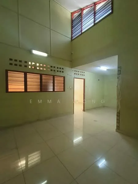 Room features: green painted walls, glossy ceramic tile flooring, high ceiling, large windows with red frames, multiple light fixtures, open layout, doorway leading to another room, wall with ventilation openings.