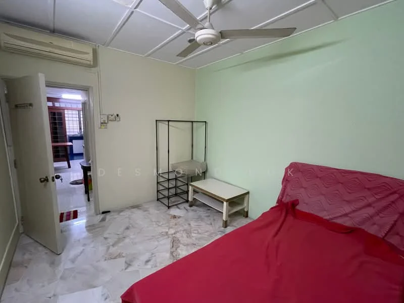 Bedroom features: green painted walls, marble flooring, ceiling fan, double bed with red bedspread, wooden door, glass display cabinet, small coffee table.